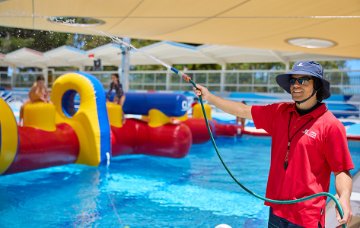 Man hosing water for the pool inflatable